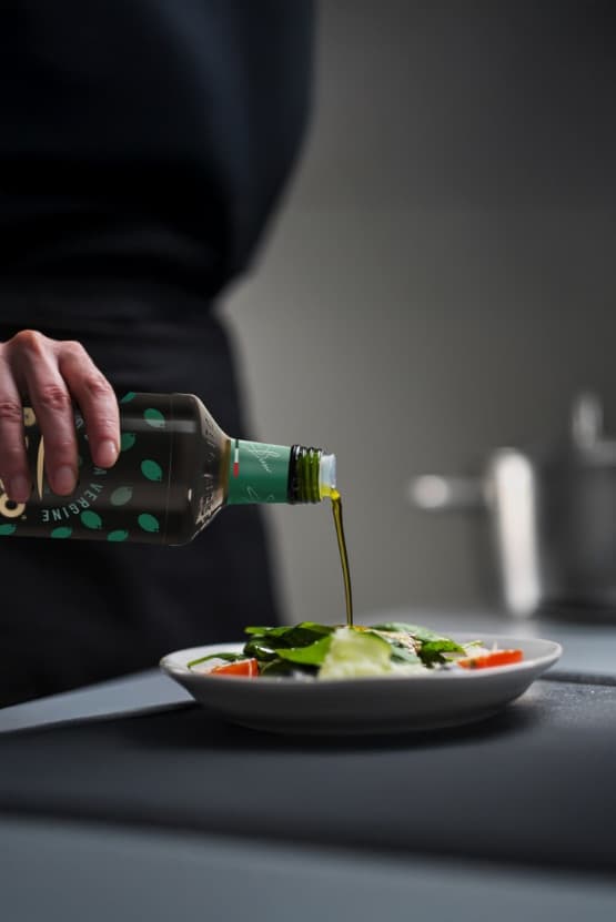 Olive oil being poured on salad