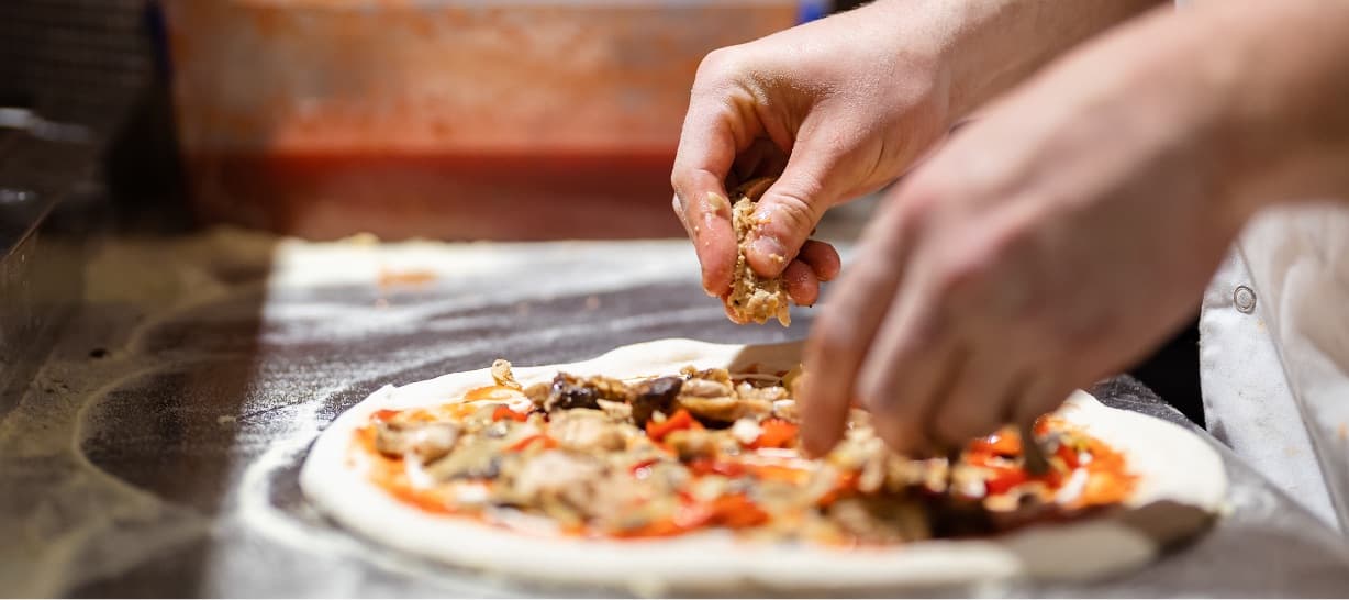 Pizza being prepared with olive oil